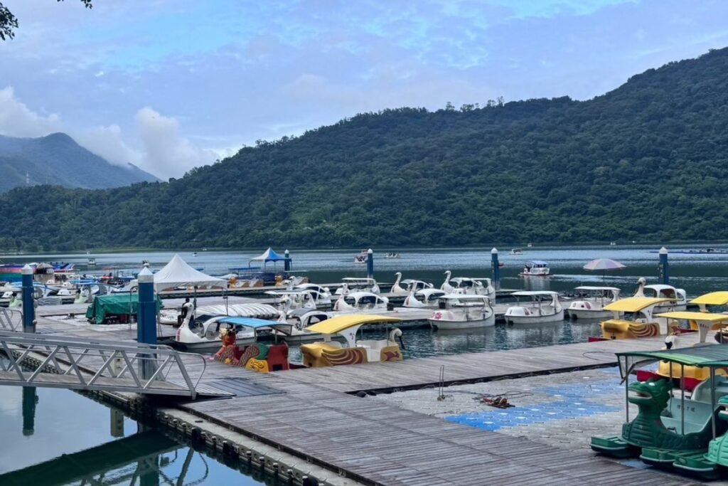 潭面上色彩繽紛的天鵝船與熱鬧的遊湖碼頭風景